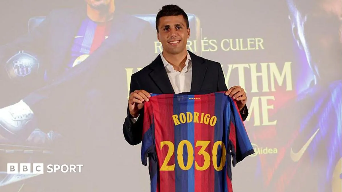 Rodri holds up a Barcelona shirt after completing his transfer