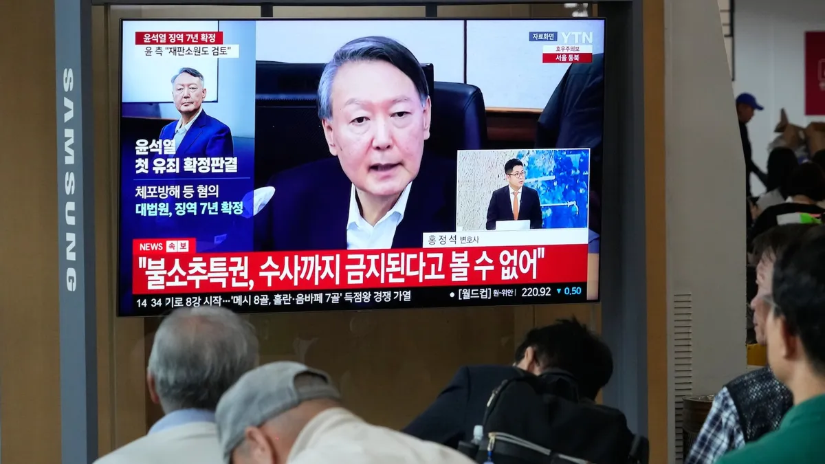 TV screen shows Yoon Suk Yeol at Seoul Railway Station following Supreme Court ruling