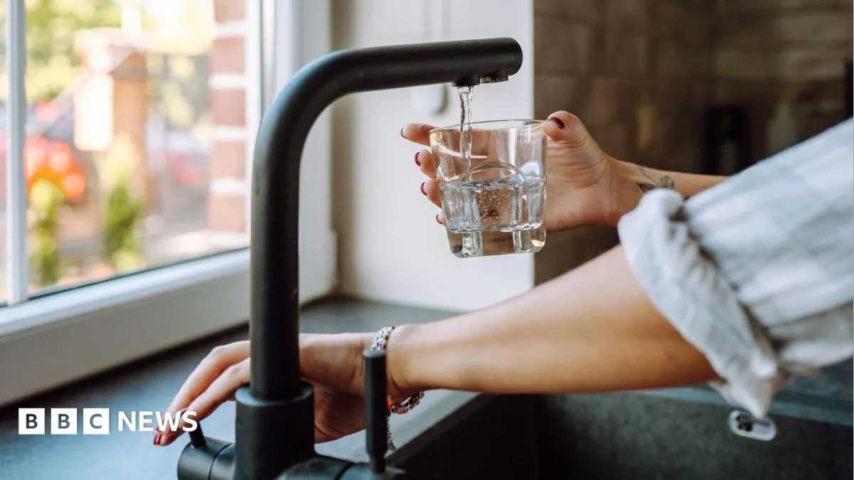 Water tap filling a glass - UK water bill increase